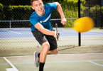 A pickleball player hitting a successful dink shot.