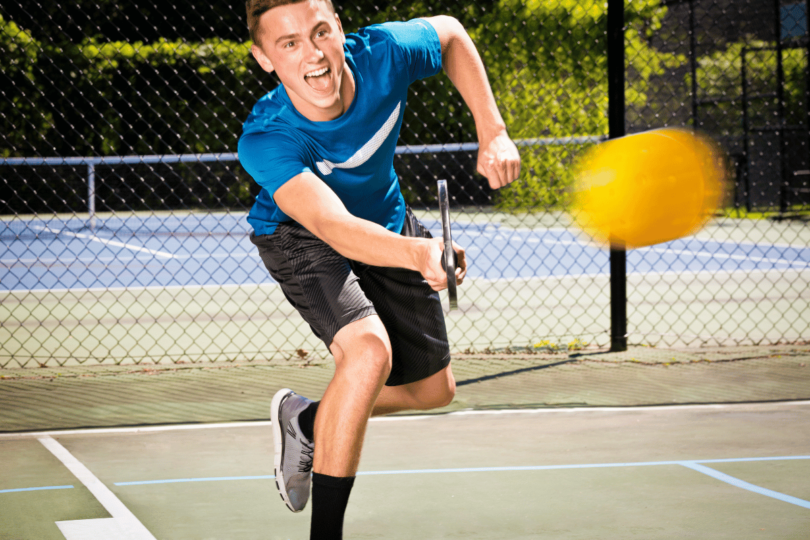 A pickleball player hitting a successful dink shot.