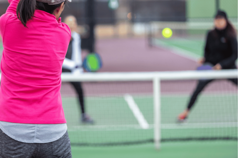 Pickleball player serving on court with proper technique.